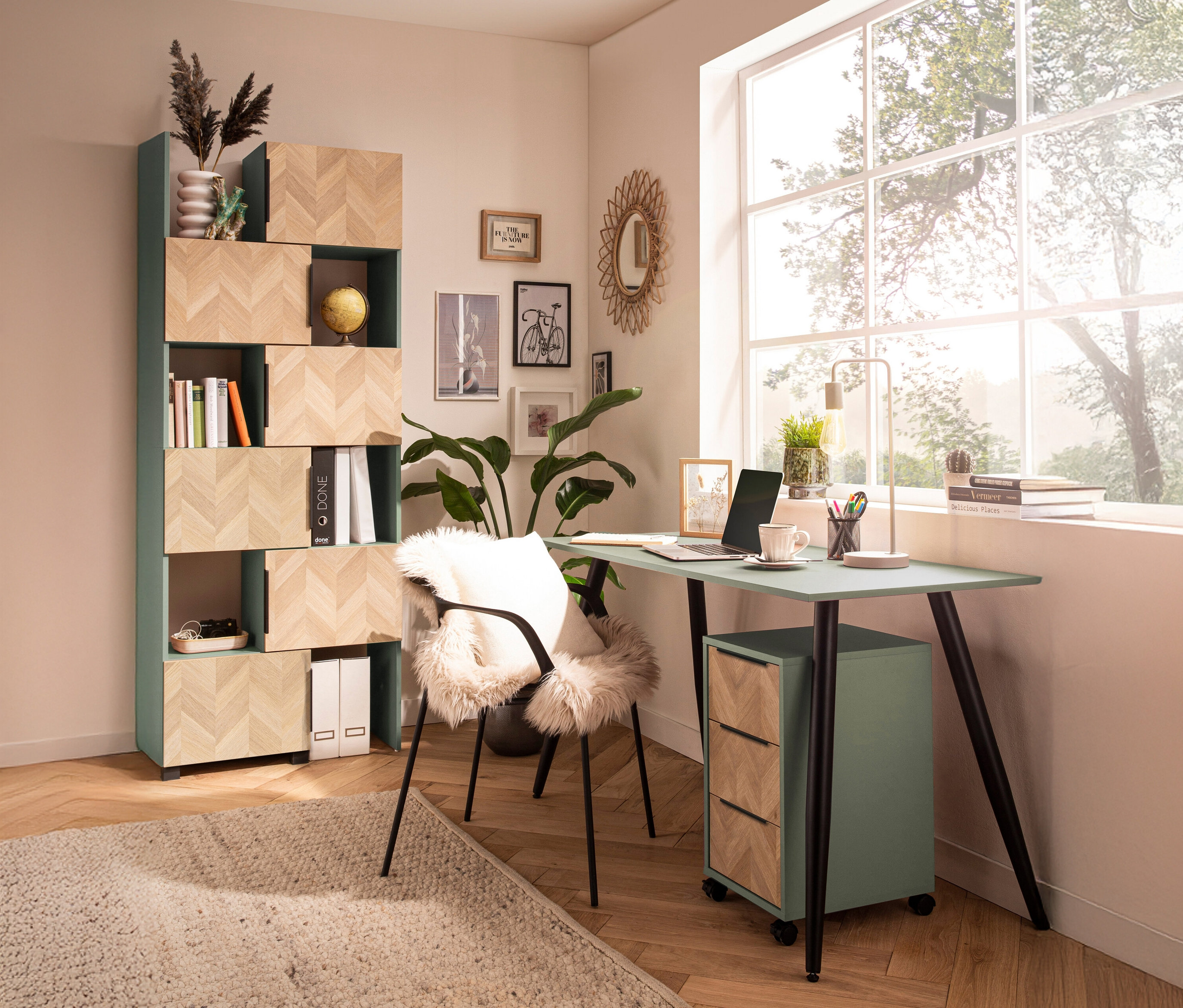 Ein Arbeitszimmer mit einem mintgrünen Schreibtisch, einem Bücherregal und einem Stuhl mit Fellauflage.