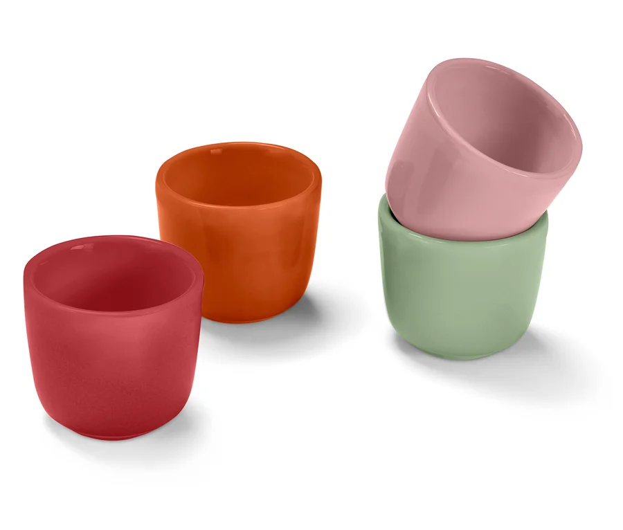 Vier kleine, runde Tassen in Rot, Orange, Hellgrün und Rosa. Die rosa Tasse steht auf der hellgrünen Tasse.