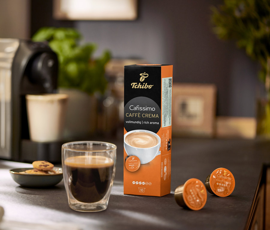 Kaffeemaschine mit Tasse Kaffee, Keksen und Packung Cafissimo Caffè Crema vollmundig - 10 Kapseln.