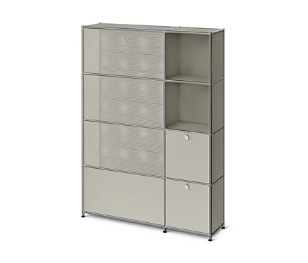 Graues, modulares Aufbewahrungsmöbel mit Chromrahmen. Links drei perforierte Türen und eine geschlossene Tür unten, rechts zwei offene Fächer und zwei geschlossene Türen mit runden Griffen.