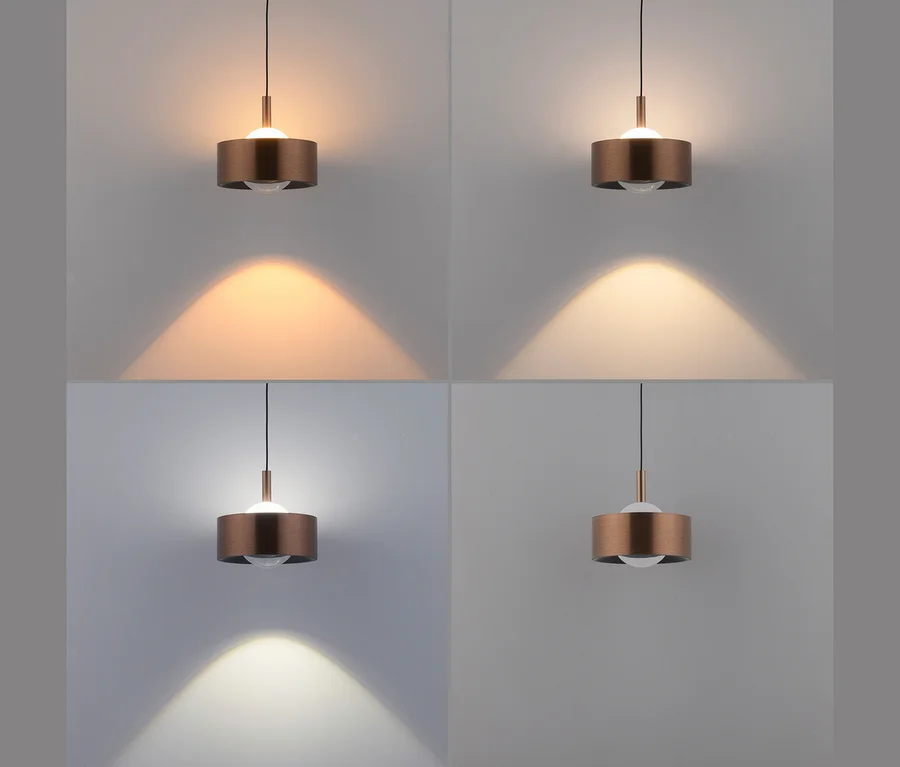 Vier Ansichten einer Pendelleuchte mit zylindrischem Kupferschirm und weißer Kugelbirne, die verschiedene Lichttemperaturen zeigt: warmgelb, warmweiß, kaltweiß und sehr kaltweiß.
