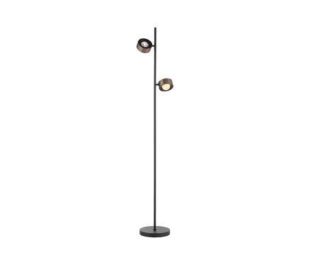Eine Stehlampe mit schwarzem Stab und rundem Fuß, an der zwei runde, metallisch-bronzefarbene, beleuchtete Strahler befestigt sind, einer oben, einer mittig.