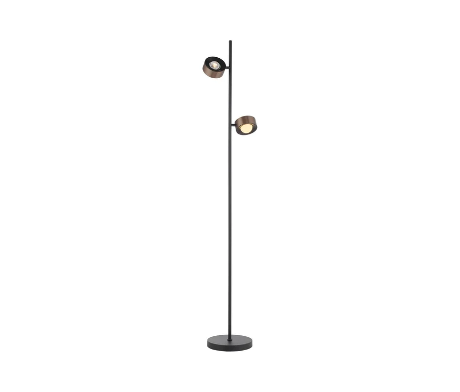 Eine Stehlampe mit schwarzem Stab und rundem Fuß, an der zwei runde, metallisch-bronzefarbene, beleuchtete Strahler befestigt sind, einer oben, einer mittig.