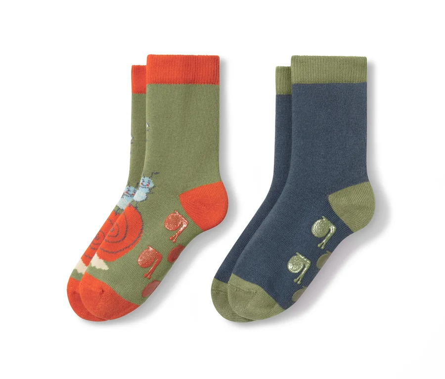 Zwei Paar Kinder-Antirutsch-Socken. Ein Paar ist olivgrün mit orangefarbenen Details und Schneckenmuster, das andere Paar ist blau mit grünen Details und Froschmuster.