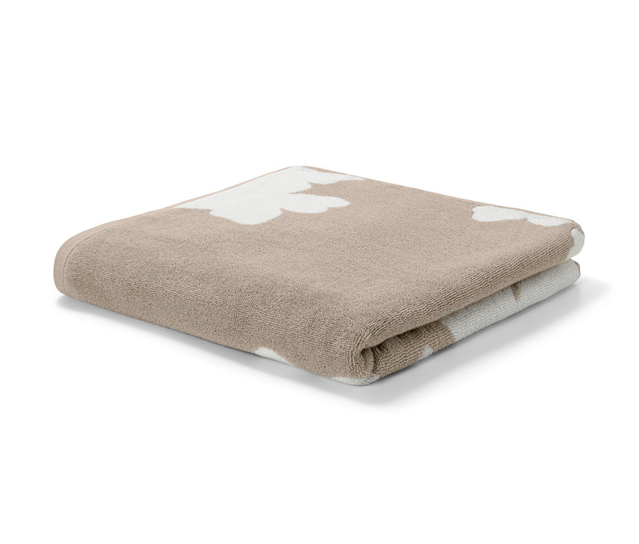 Ein beige Jacquard-Badetuch liegt gefaltet auf einem weißen Hintergrund.
