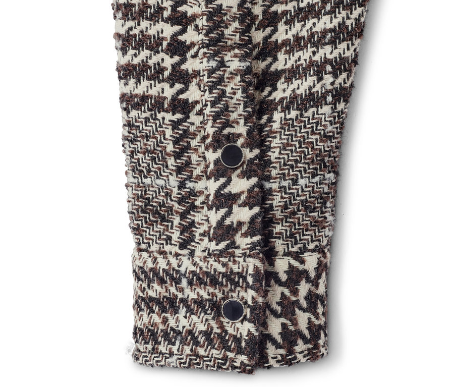 Detail einer Hemdjacke mit Hahnentrittmuster und Knöpfen.