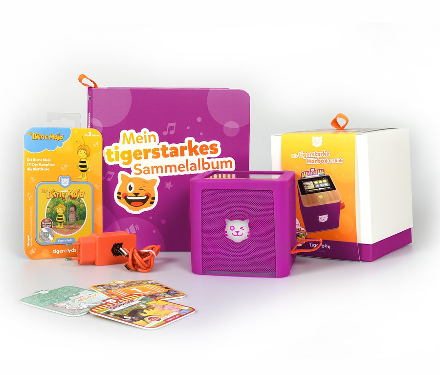 Lila »tigerbox TOUCH« Paket, Ladegerät, Album, Karten und Biene Maja Figur auf weissem Hintergrund.