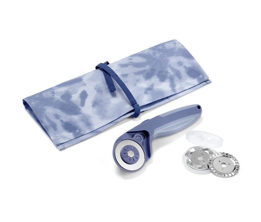 Ein Stoff-Rollschneider liegt neben einer Stoffhülle mit Krawatte.