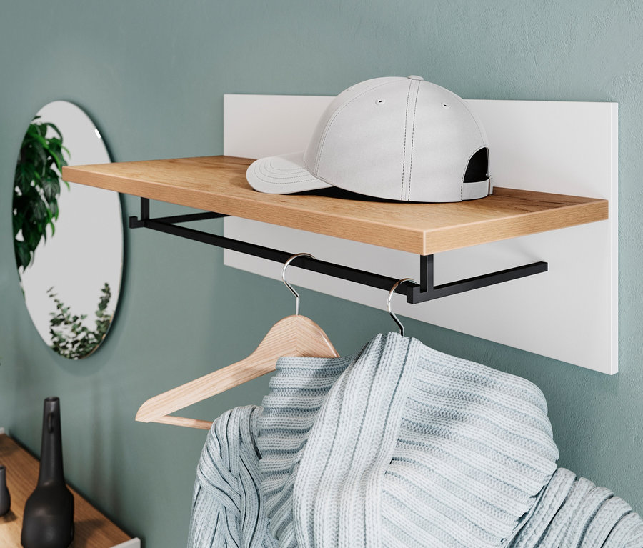 Auf einem »Lucena« Garderobenpaneel liegt eine weiße Kappe. Darunter hängt ein Pullover an einem Kleiderbügel.