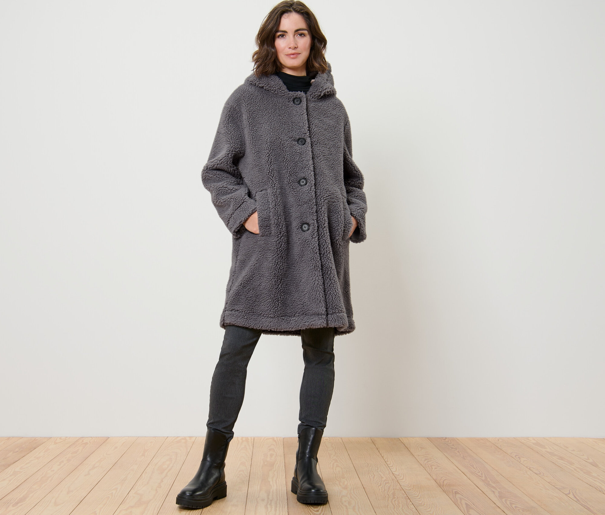 Frau posiert in Teddymantel mit Kapuze.