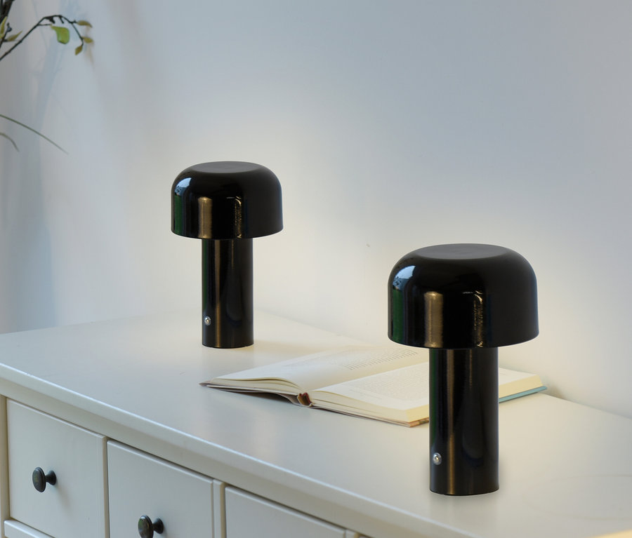 Zwei schwarze JUST LIGHT LED-Akku-Tischleuchten »Agnes« auf einem weißen Tisch mit einem offenen Buch.