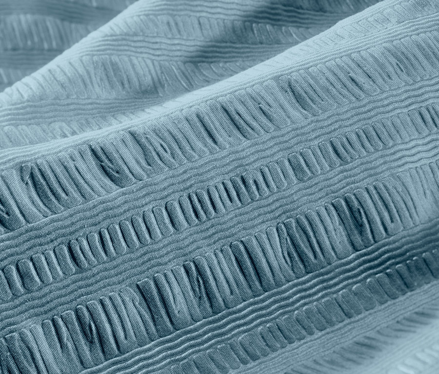 Nahaufnahme von blauer Seersucker-Bettwäsche.