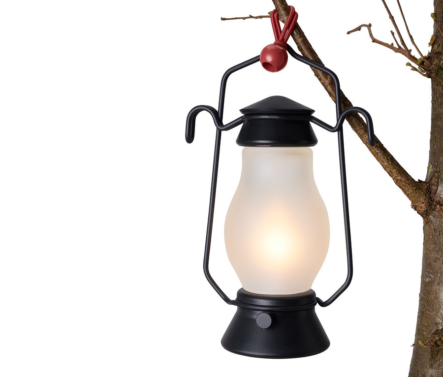 Schwarze Laterne hängt mit 12 Spanngummis an einem Baumast.