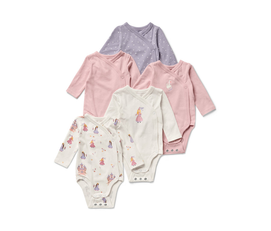 Fünf Baby-Bodys mit Mitwachsfunktion im Prinzessin-Design. Die Bodys sind helllila mit Punkten, rosa und weiss mit Prinzessinen-Motiven.