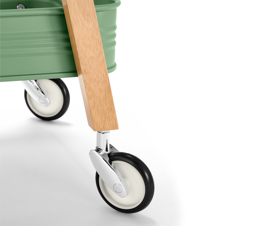 Detailansicht eines Küchen-Servierwagens mit grüner Oberseite, Holzgriff und Rädern.