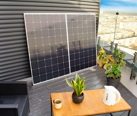 Zwei Solar-Balkonkraftwerke »TX220« 600 W stehen nebeneinander auf einem Balkon, im Hintergrund ist eine Stadt zu sehen.
