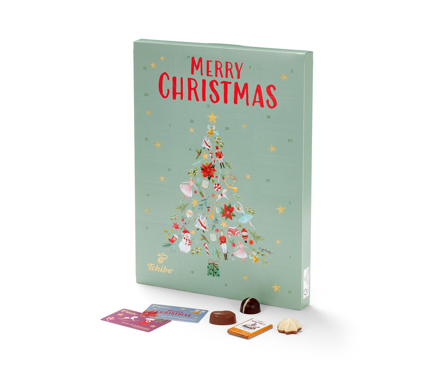 Ein grüner Tchibo Adventskalender mit Weihnachtsbaum-Motiv und Zahlen, Pralinen und Karten darunter.