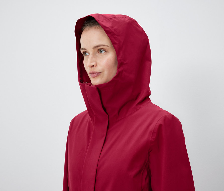 Frau trägt eine rote Jacke mit Kapuze.
