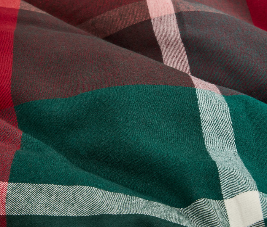 Detailaufnahme eines Stoffes mit Karomuster in Grün, Braun, Rot und Weiß.