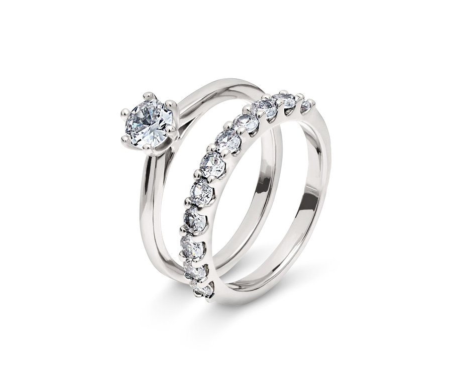 Zwei silberne Ringe, einer mit einem einzelnen Brillanten, der andere mit einer Reihe von Brillanten.