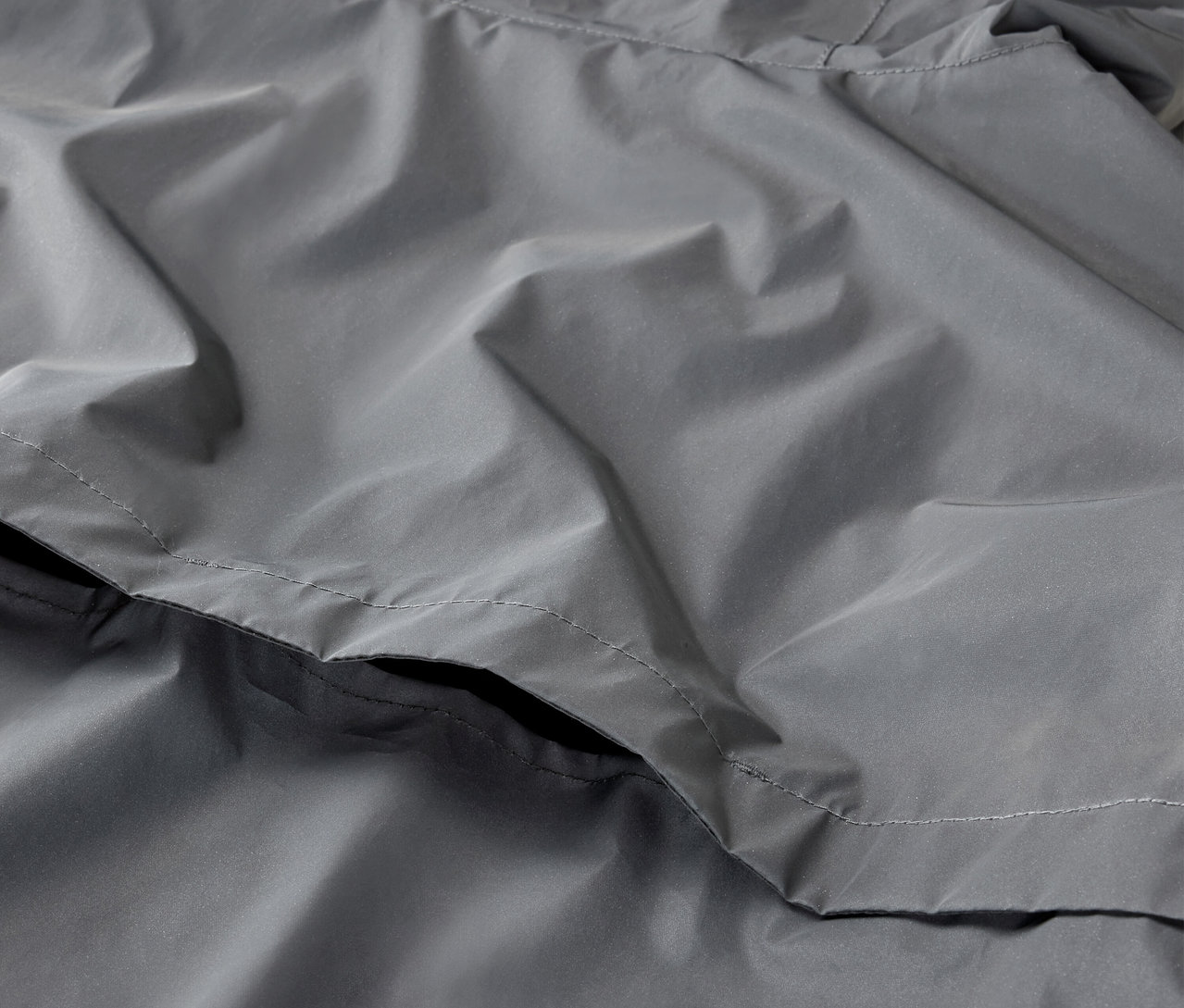 Detailaufnahme einer grauen, reflektierenden Sportjacke.