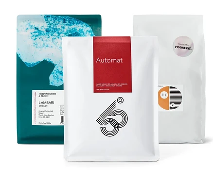 Drei Kaffeepackungen, darunter eine Packung Espresso Probierset "Rundreise durch Südamerika" - 3x 1 kg Ganze Bohne.