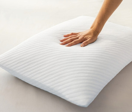 Eine Hand berührt ein weißes, strukturiertes TEMPUR PRIMA® Schlafkissen Medium.