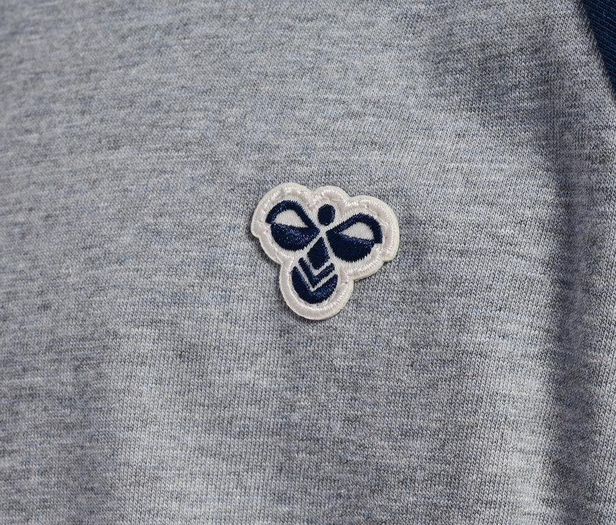 Graues T-Shirt mit blauen Raglanärmeln und Hummel-Logo.