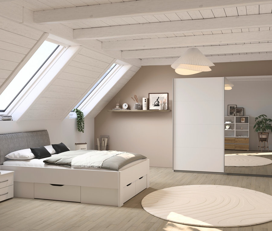 Ein Schlafzimmer im Dachgeschoss mit einem weißen rauch Bett »Aditio Beds«, 140 cm mit Kopfteil, Nachttisch und einem Kleiderschrank mit Spiegeltüren.