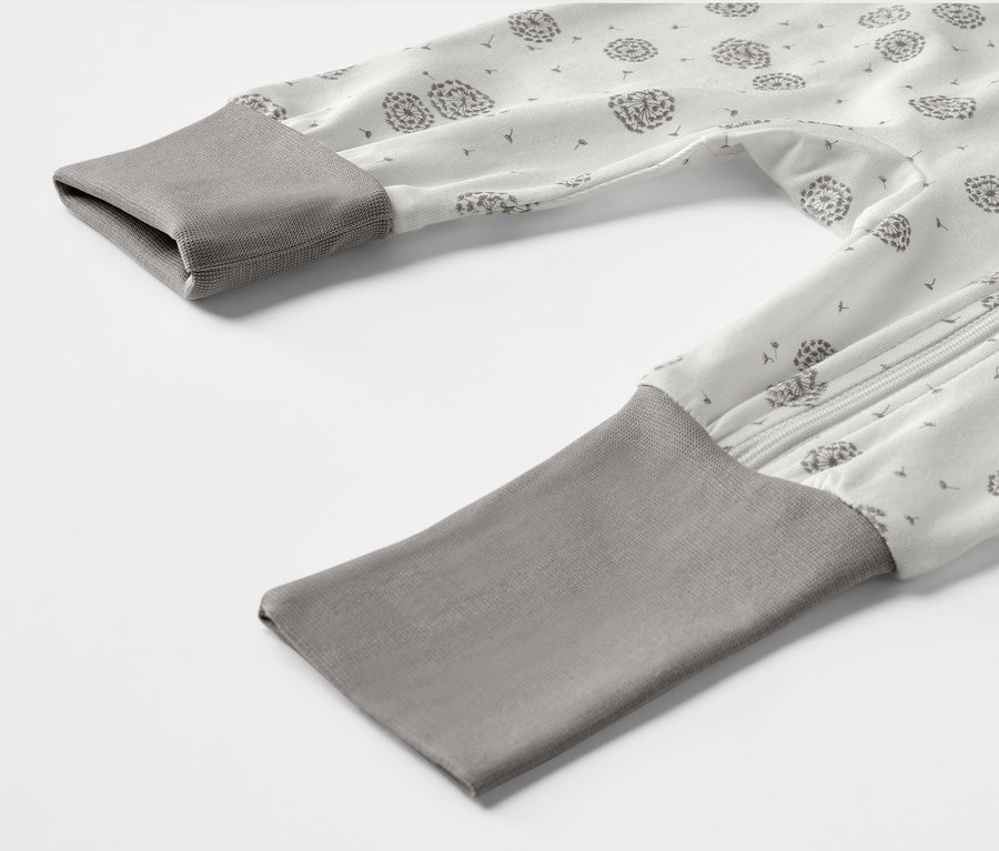 Detailansicht eines Baby-Schlafanzugs mit Löwenzahn-Muster.