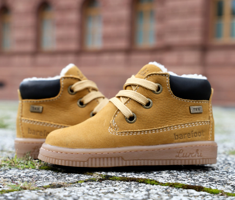 Zwei braune LURCHI »Fleximo Barefoot-TEX« Barfußschuhe auf Pflastersteinen.