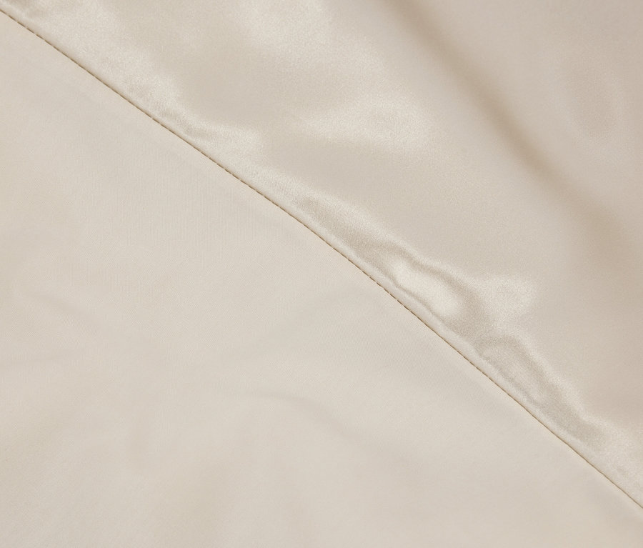 Detailaufnahme eines cremefarbenen Stoffes mit diagonaler Naht.