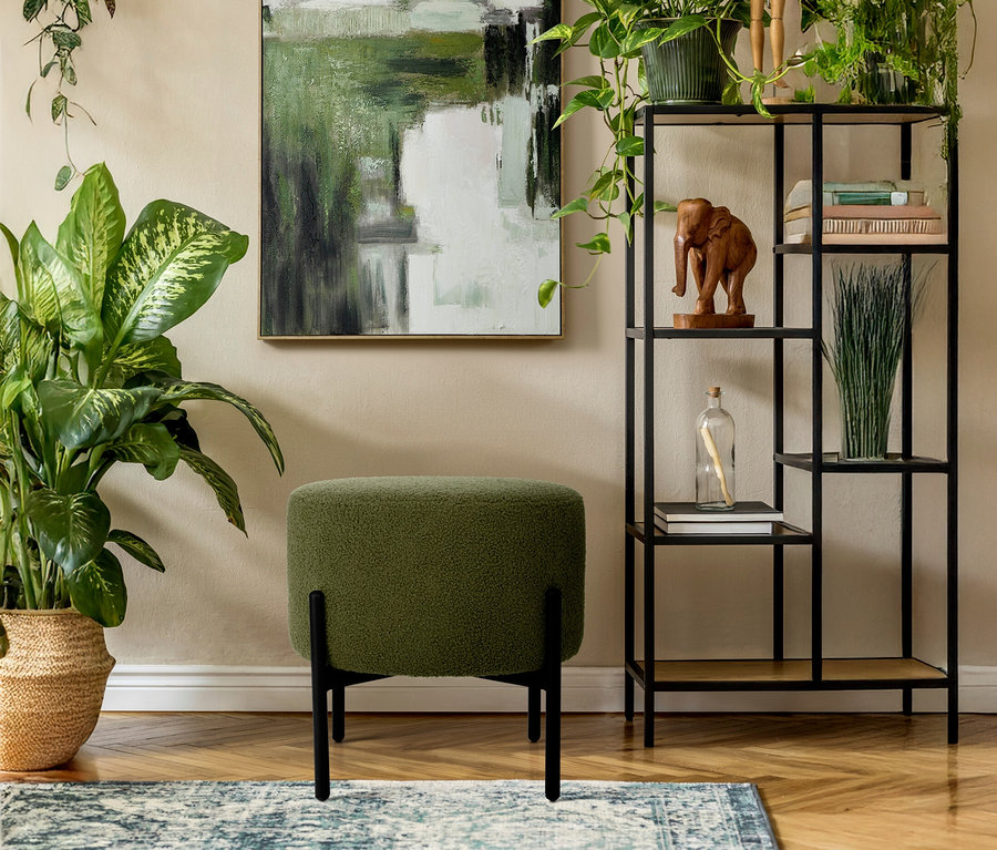 Ein grüner Eglo Hocker »MANIRENJA« steht auf einem Teppich vor einer Wand mit einem abstrakten Gemälde.