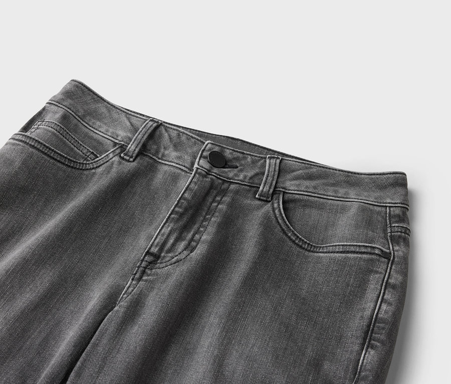 Nahaufnahme einer grauen Jeanshose mit Knopfverschluss und Taschen.