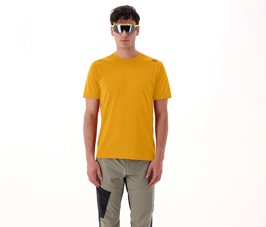Mann mit gelber Sonnenbrille und CMP Herren-T-Shirt aus Piquéstrick, curcuma, steht vor weißem Hintergrund.