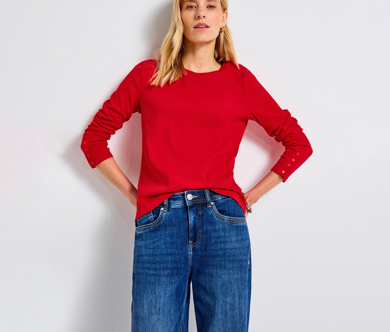 Frau mit rotem Street One Rippshirt und Jeans.