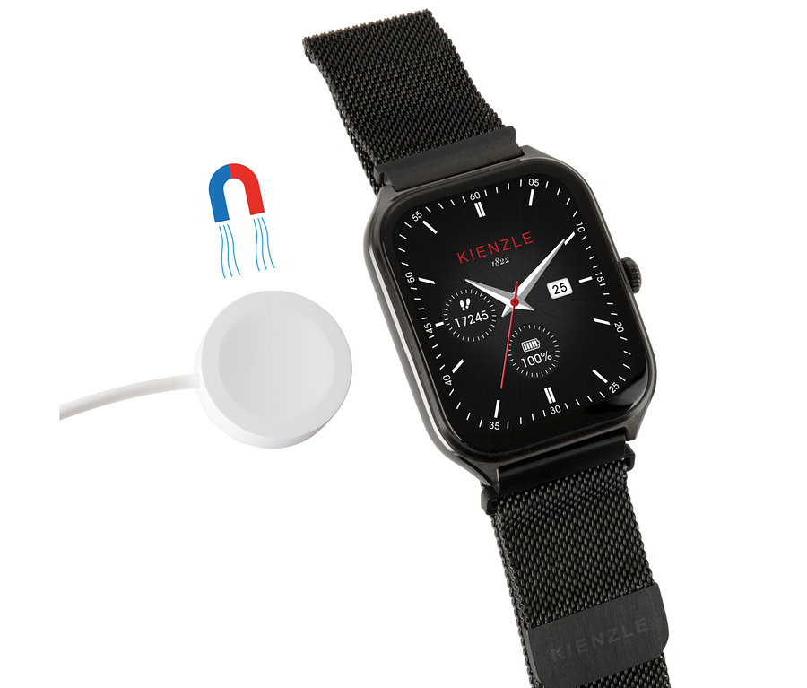 Schwarze Kienzle Uhr »Smart Slim« mit Mesh-Armband und einem weißen kabellosen Ladegerät daneben.