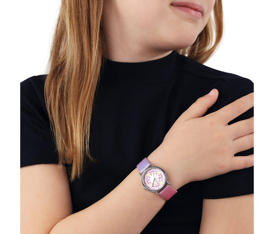 Junge Person in einem schwarzen Rippen-Top mit einer Uhr am linken Handgelenk. Die Uhr hat ein silbernes Gehäuse, ein weißes Zifferblatt mit bunten Zahlen und ein zweifarbiges lila-rosa Armband.