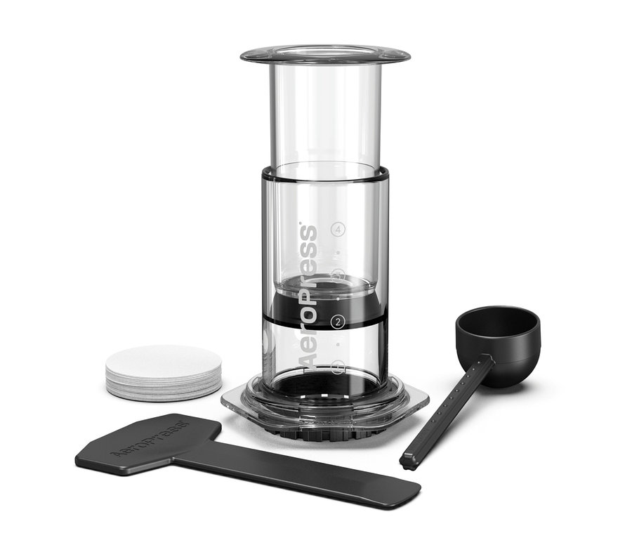 Aeropress Kaffeebereiter mit Zubehör auf weißem Hintergrund.