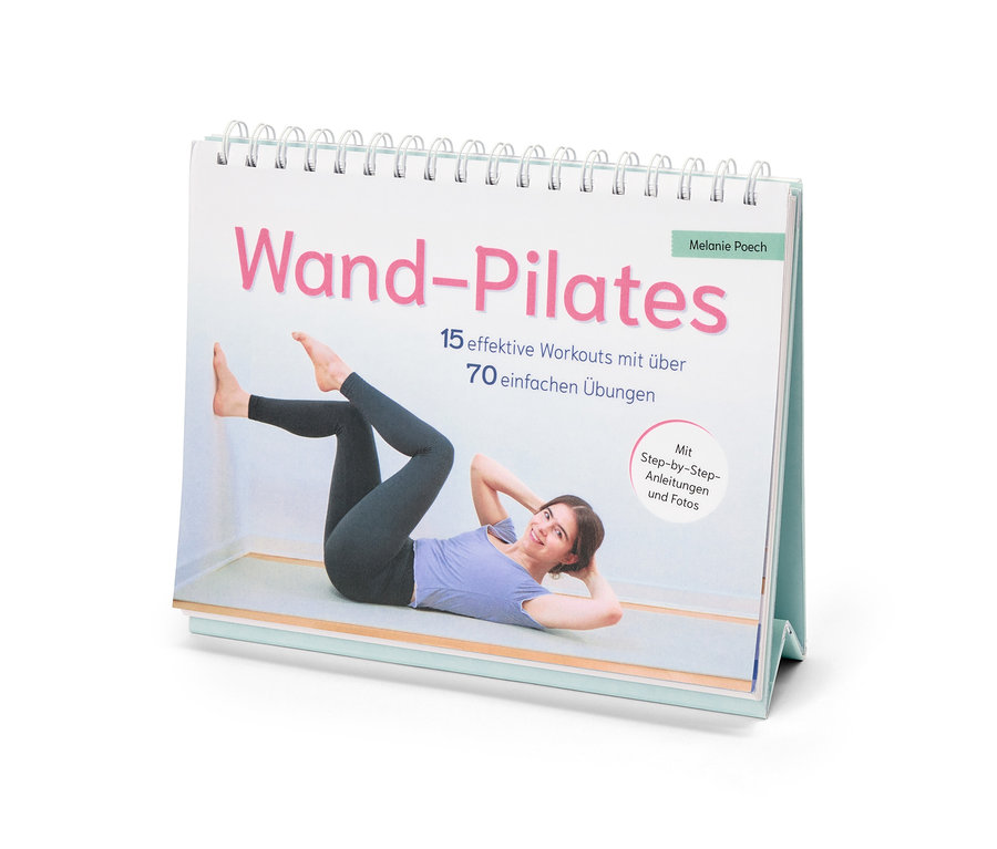 Auf dem Tisch steht ein Wand-Pilates-Buch von Melanie Poech mit 15 effektiven Workouts und über 70 einfachen Übungen.