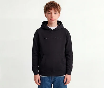 Junge Person trägt einen schwarzen Jack&Jones Star Sweat-Hoodie mit weißem Logo und blaue Jeans.