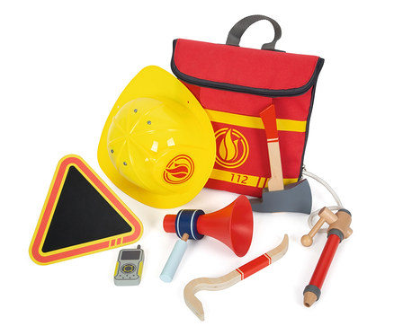 Ein gelber Feuerwehrhelm und ein small foot Feuerwehrrucksack mit Spielzeugen wie einem Megaphon und einer Axt.