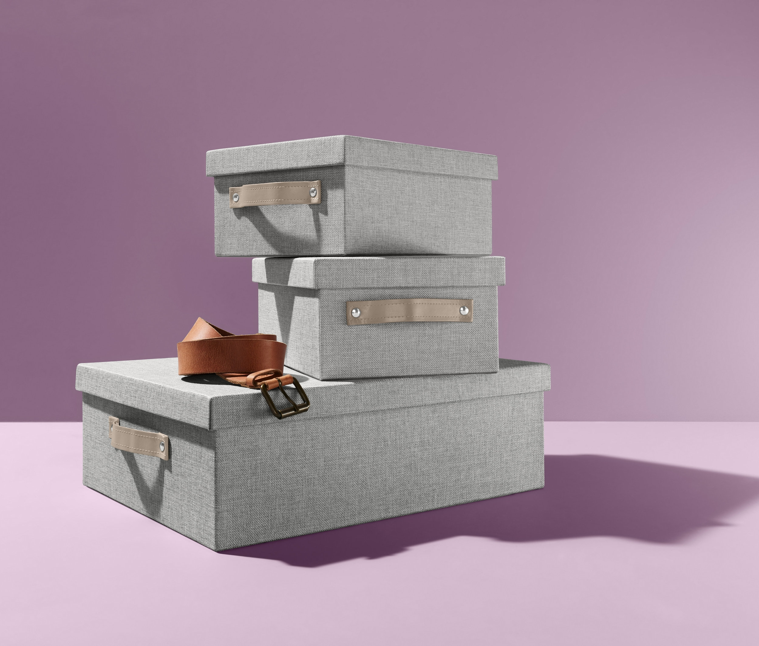 Ein Stapel Ordnungsboxen-Set und ein brauner Gürtel.