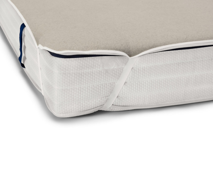 Detail einer Matratzenecke mit beigem Unterbett mit Leinen.