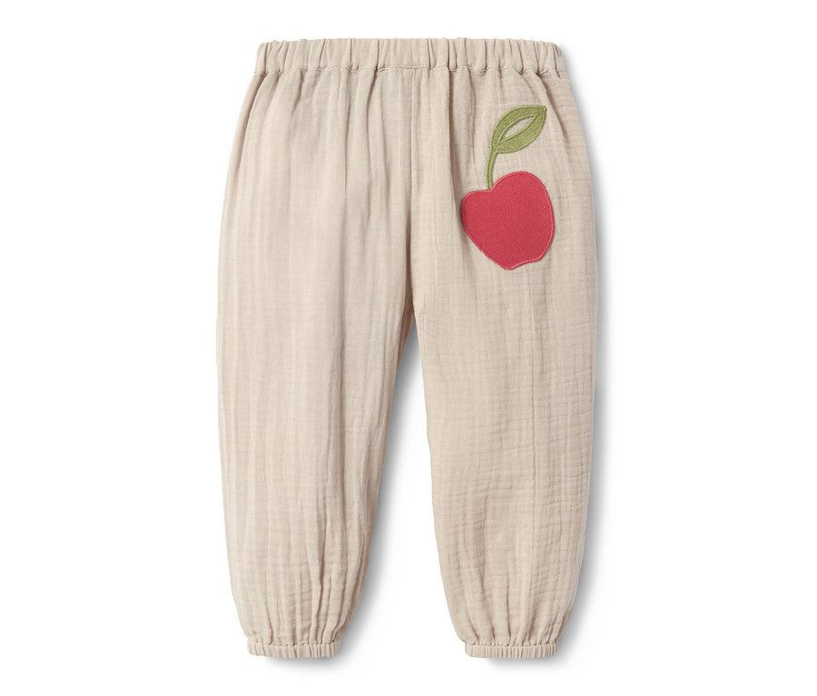 Beige Schlupfwebhose aus Bio-Baumwolle mit aufgenähter roter Kirsche.