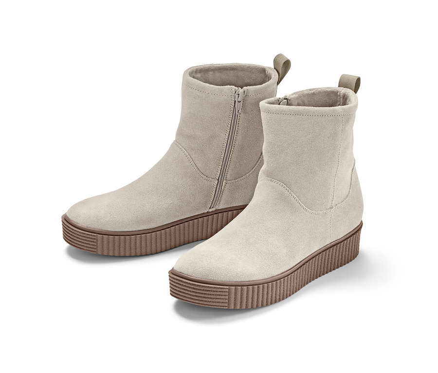 Zwei beige Veloursleder-Boots mit brauner Sohle.