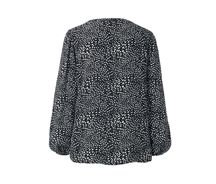 Detail einer bedruckten Bluse mit Punktemuster.