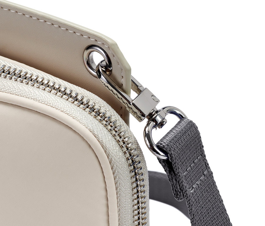 Detailaufnahme einer Mini-Tasche mit Reißverschluss und grauem Riemen.