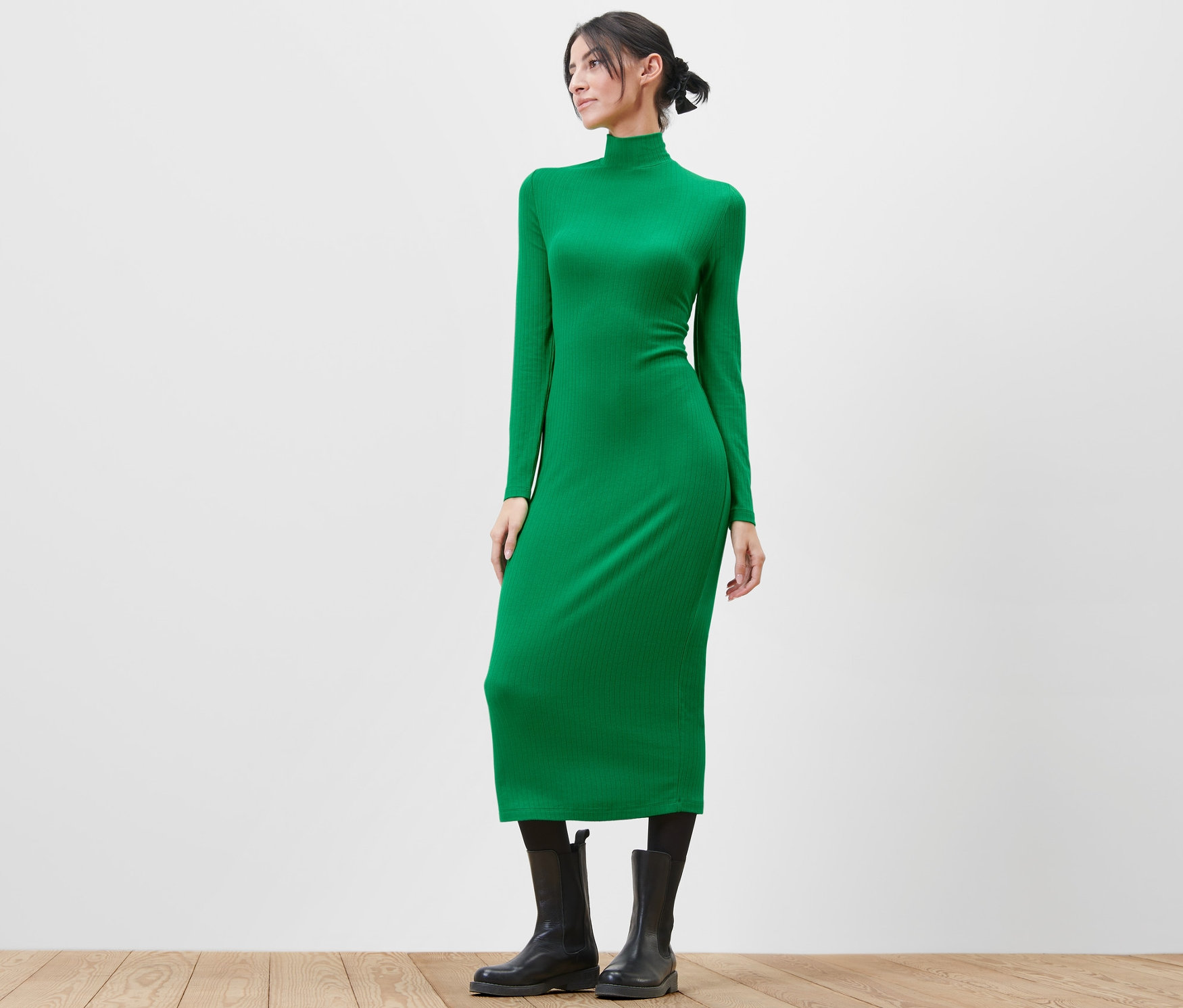 Frau posiert in einem grünen Jerseykleid.