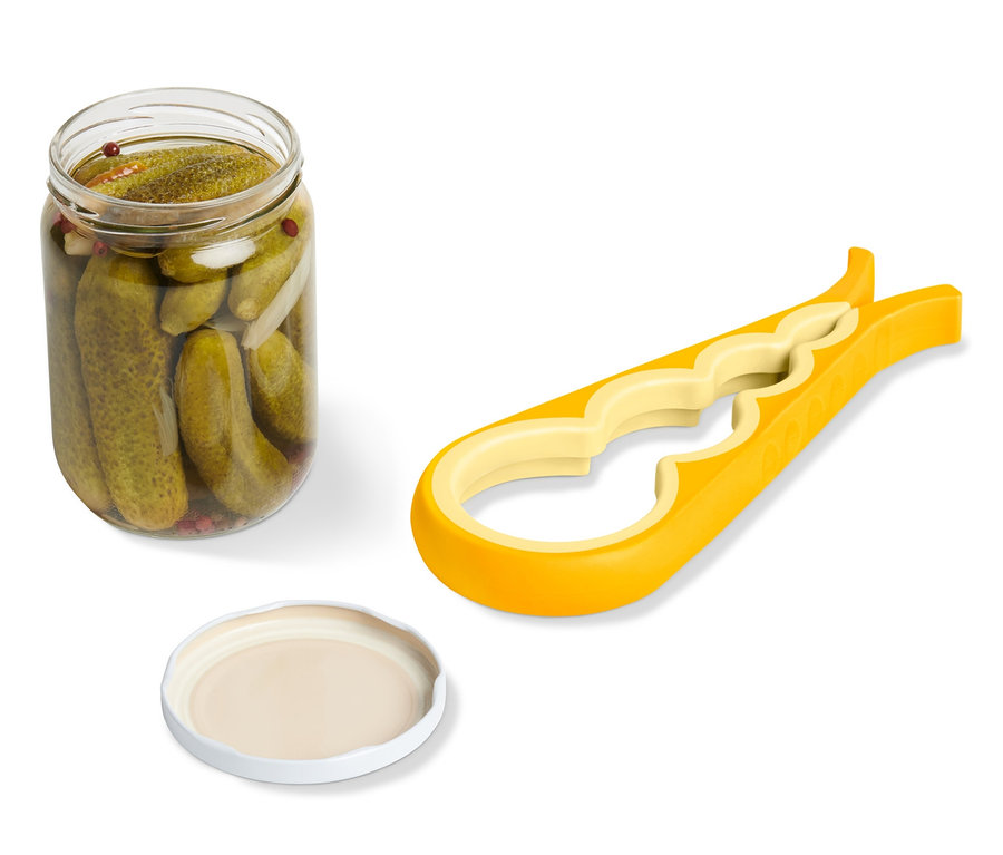 Ein Gurkenglas, ein Deckel und ein gelber Glas-und-Flaschenöffner liegen auf einem weißen Hintergrund.